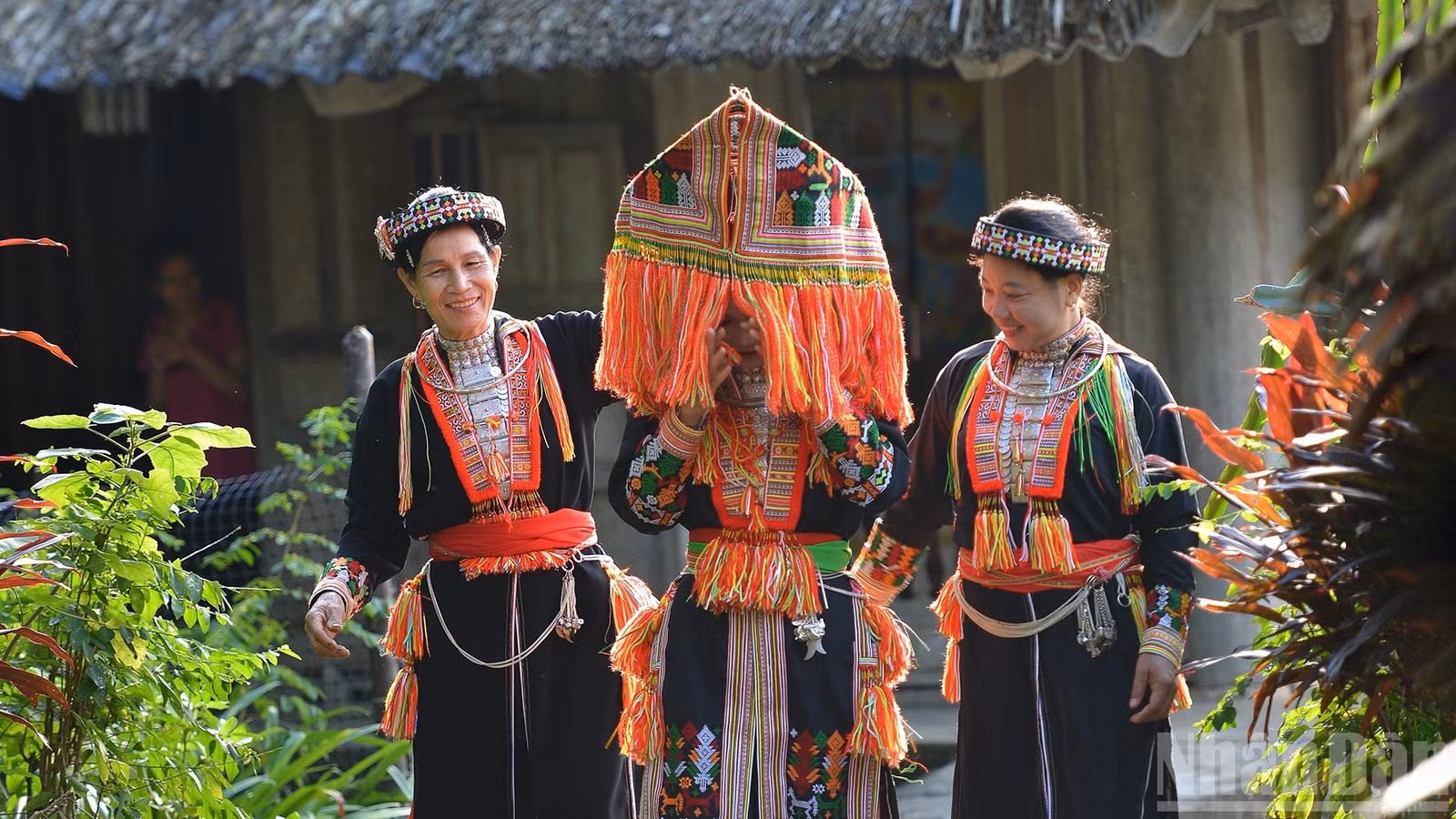 Mũ trùm kín đầu đính tua chỉ sặc sỡ.