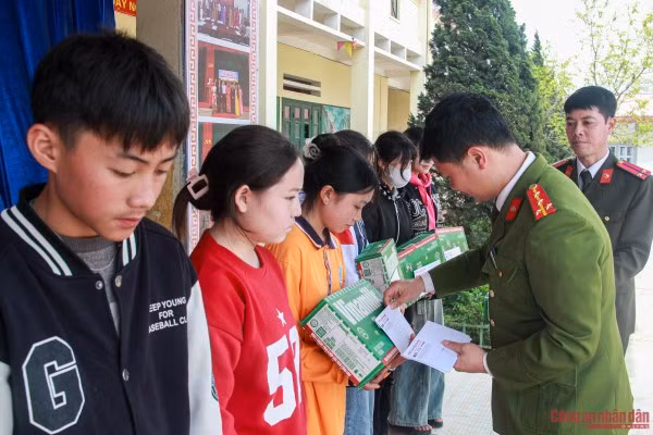Đại úy Ngô Công Thắng, Trưởng Công an xã Tả Phìn trao quà cho các em học sinh.