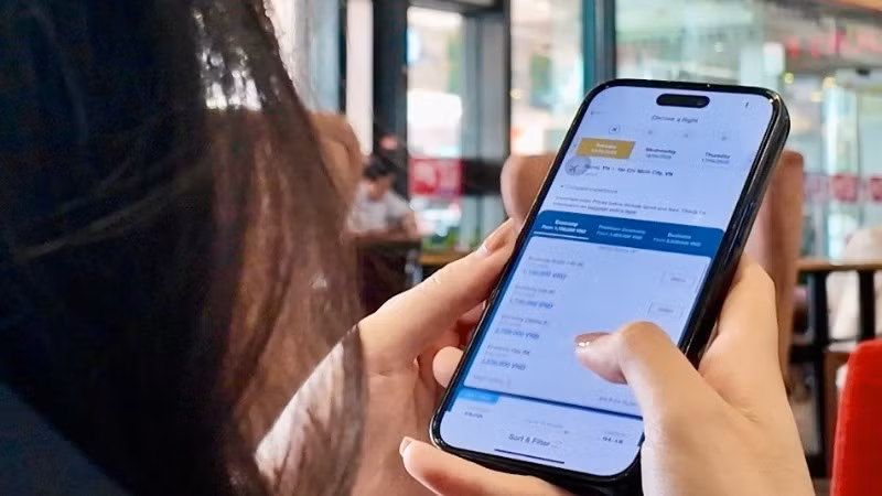 Hành khách làm thủ tục hàng không trực tuyến trước giờ khởi hành. (Ảnh: NGHĨA HƯNG)