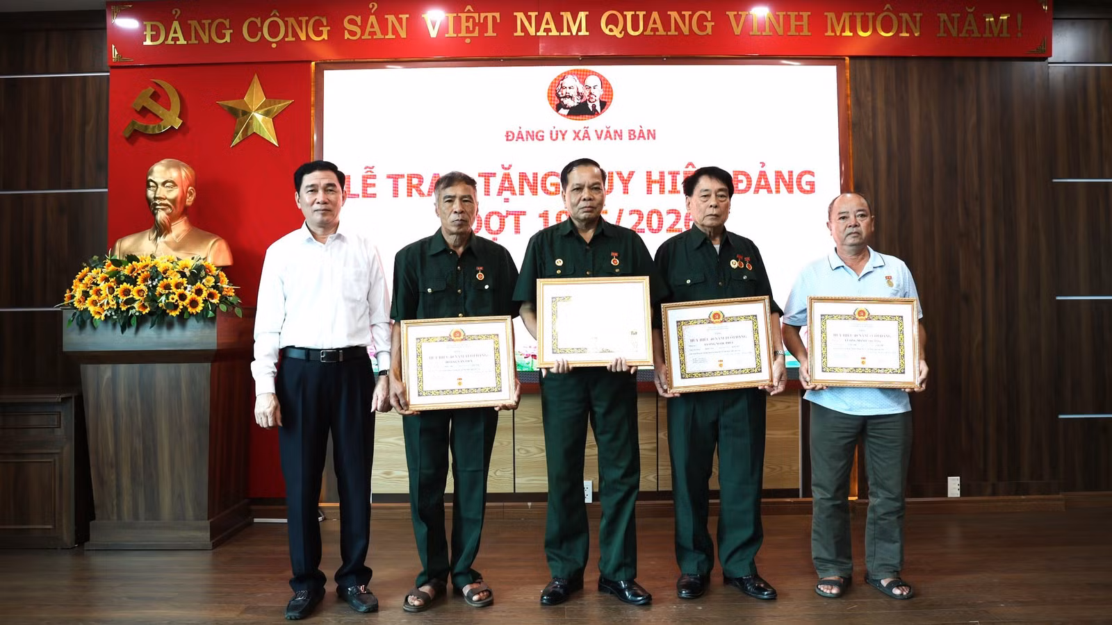 Đồng chí Nguyễn Minh Toàn và Thường trực Đảng ủy xã trao Huy hiệu Đảng cho đảng viên.