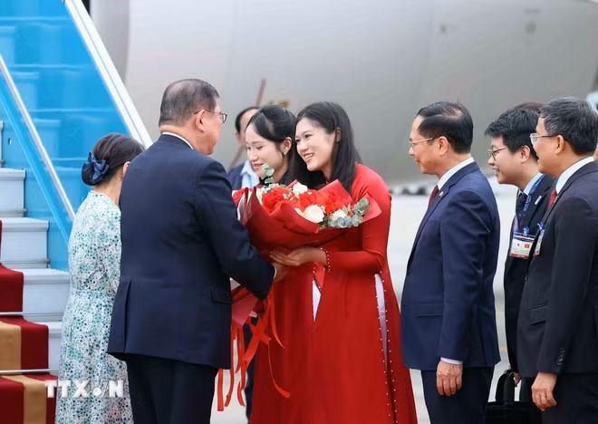 Thiếu nữ Hà Nội tặng hoa, chào mừng Thủ tướng Nhật Bản Ishiba Shigeru và Phu nhân thăm chính thức Việt Nam.