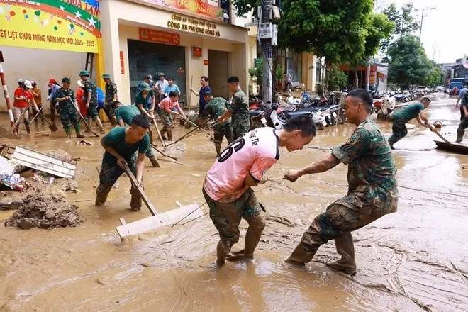 Bộ đội giúp Nhân dân thành phố Yên Bái dọn bùn đất sau lũ quét.
