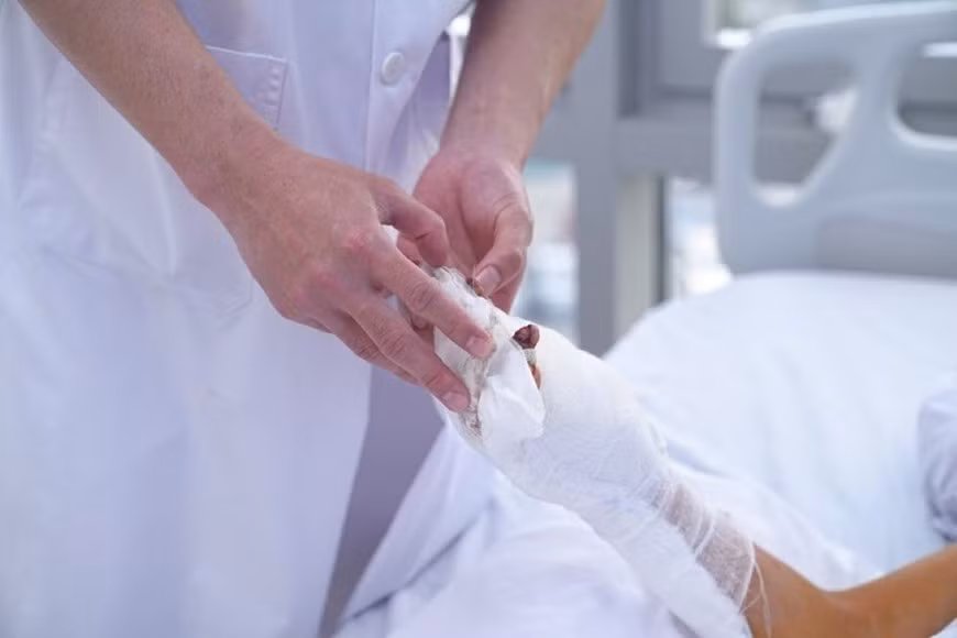 Bác sĩ chăm sóc vết thương ở tay của bệnh nhân nhi 12 tuổi ở Quảng Ninh do sử dụng pháo tự chế. Ảnh: VGP