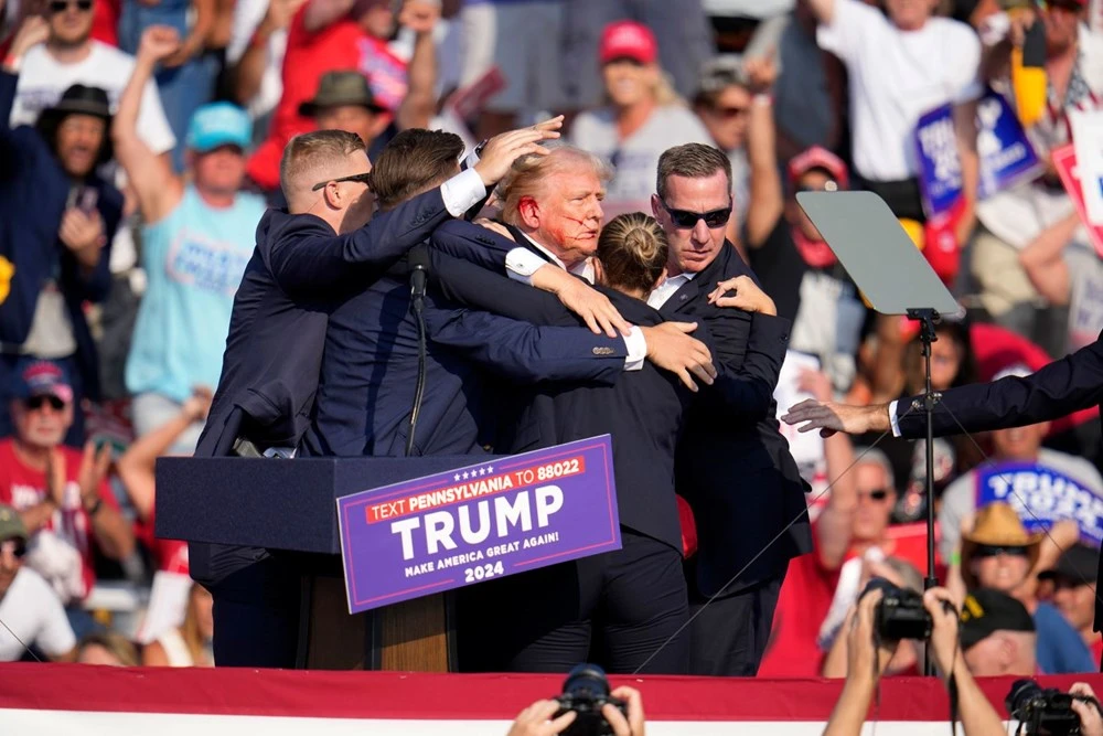 Cựu Tổng thống Donald Trump được nhân viên an ninh đưa ra khỏi hiện trường.