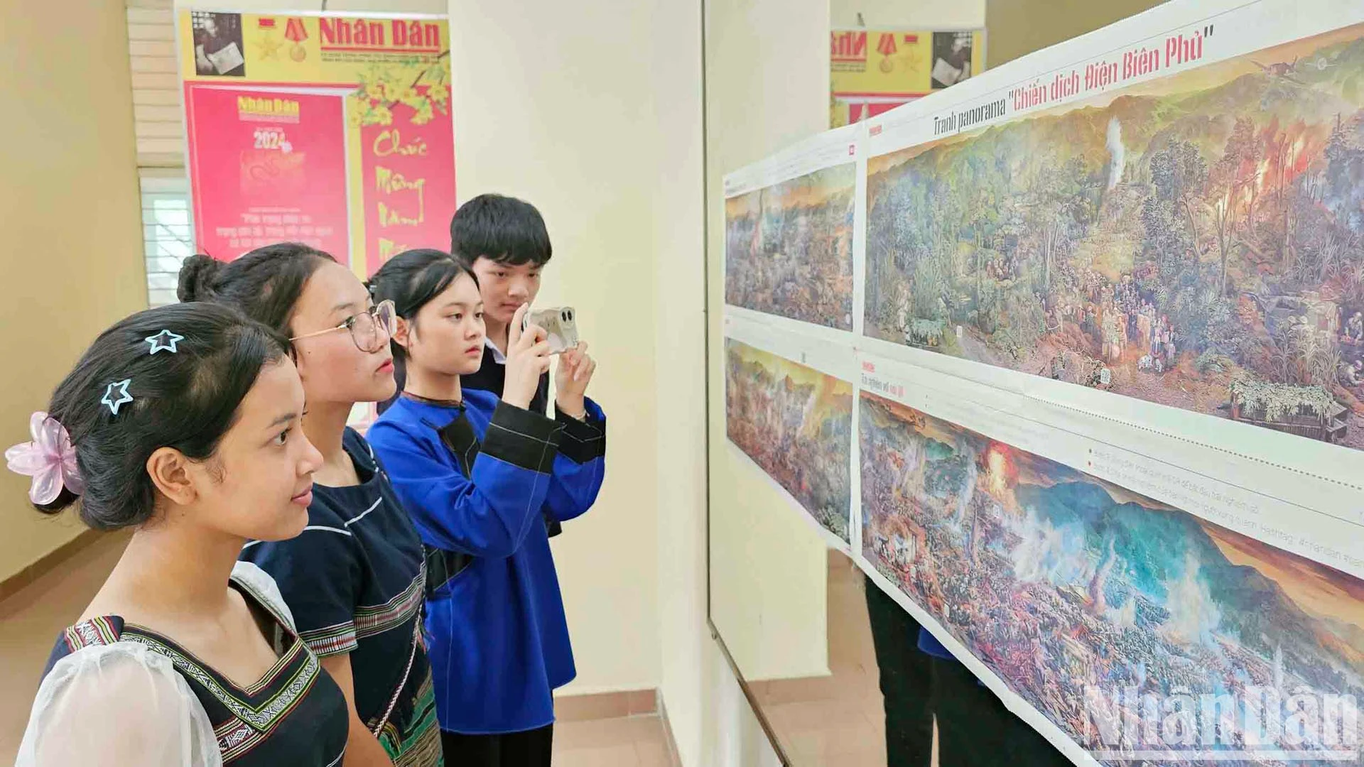 Các bạn trẻ đồng bào dân tộc thiểu số quét mã QR khám phá "bí ẩn" trên ấn bản tranh panorama "Chiến dịch Điện Biên Phủ".
