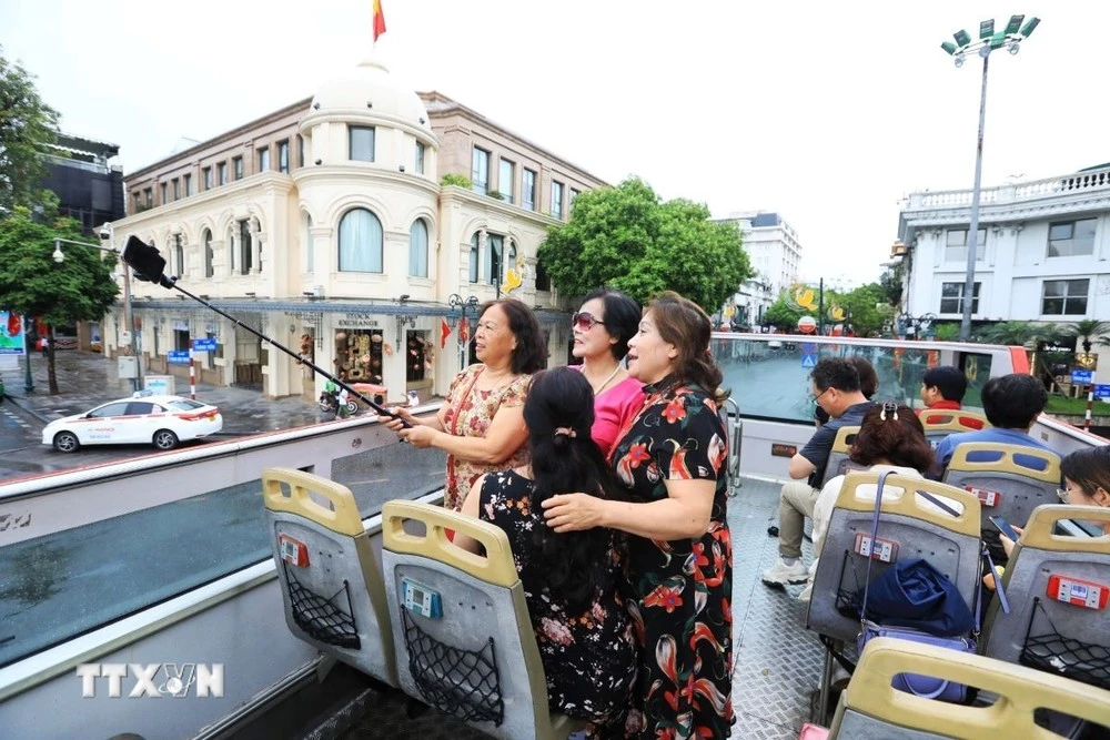Du khách hào hứng khi được tham quan Hà Nội bằng xe buýt 2 tầng.