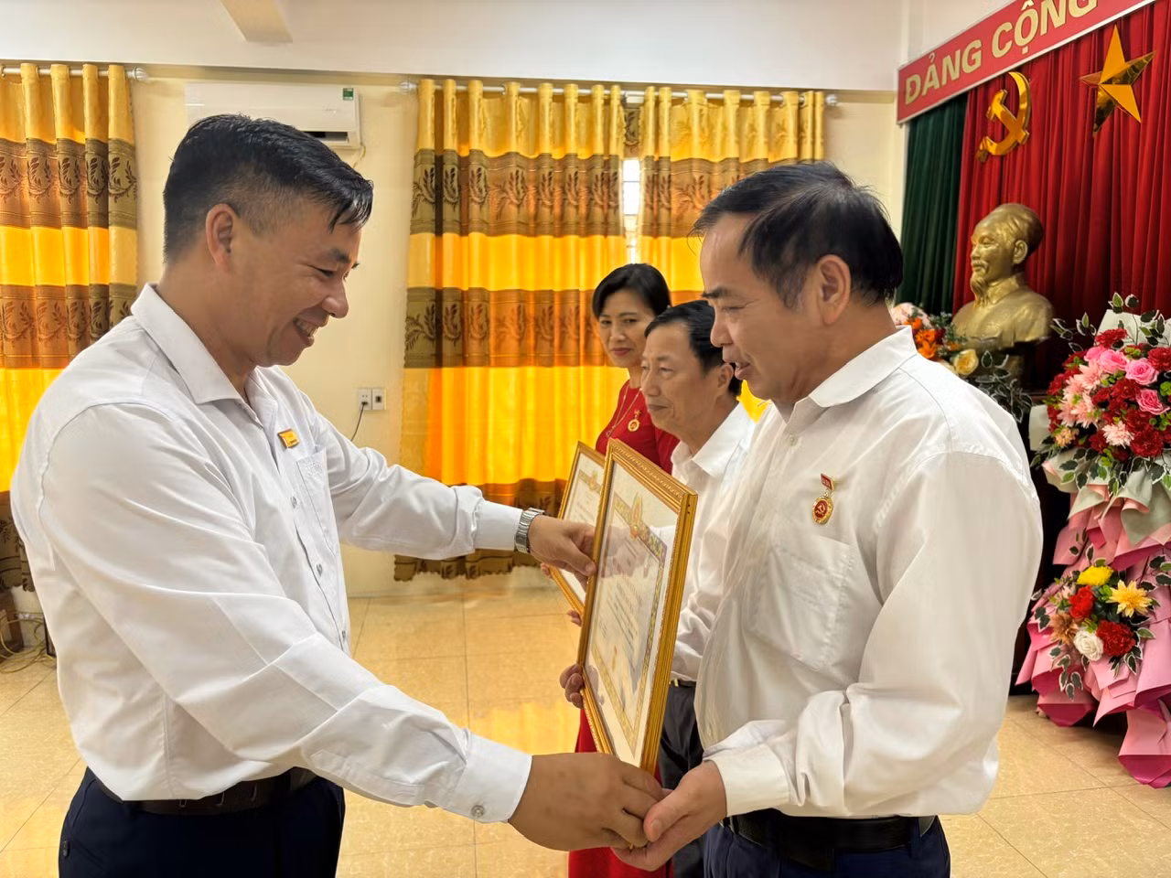 Bí thư Đảng ủy thị trấn Phố Ràng trao Huy hiệu đảng cho các đảng viên.jpg