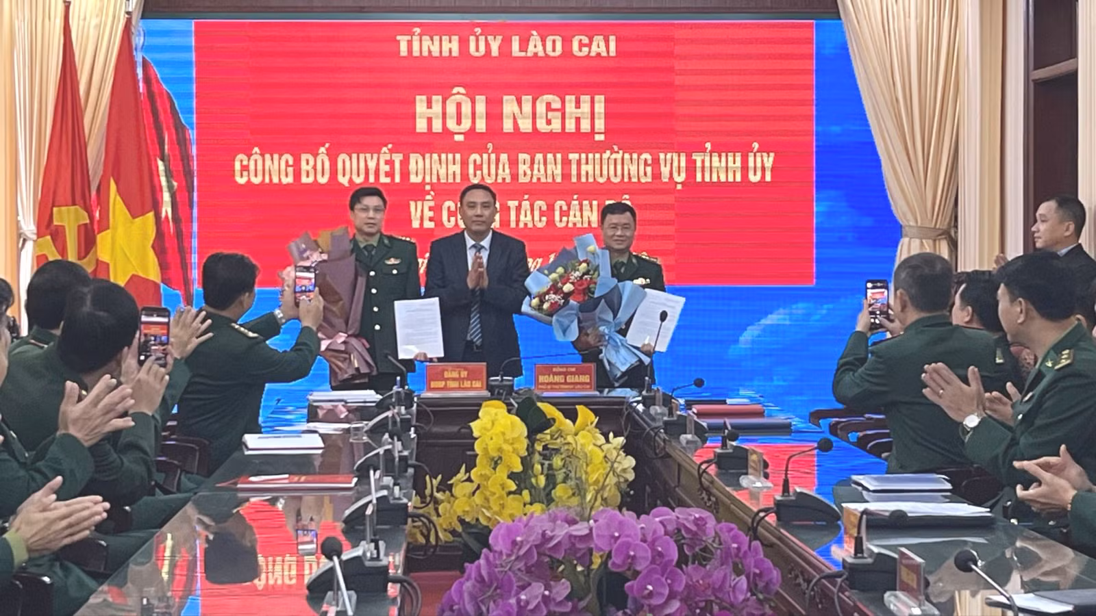 Đồng chí Hoàng Giang Phó Bí thư Tỉnh ủy, trao Quyết định và tặng hoa chúc mừng Đại tá Trần Quang Tùng Bí thư Đảng ủy và Đại tá Nguyễn Văn Tuấn, Chủ nhiệm ủy ban kiểm tra BĐBP tỉnh Lào Cai.jpg