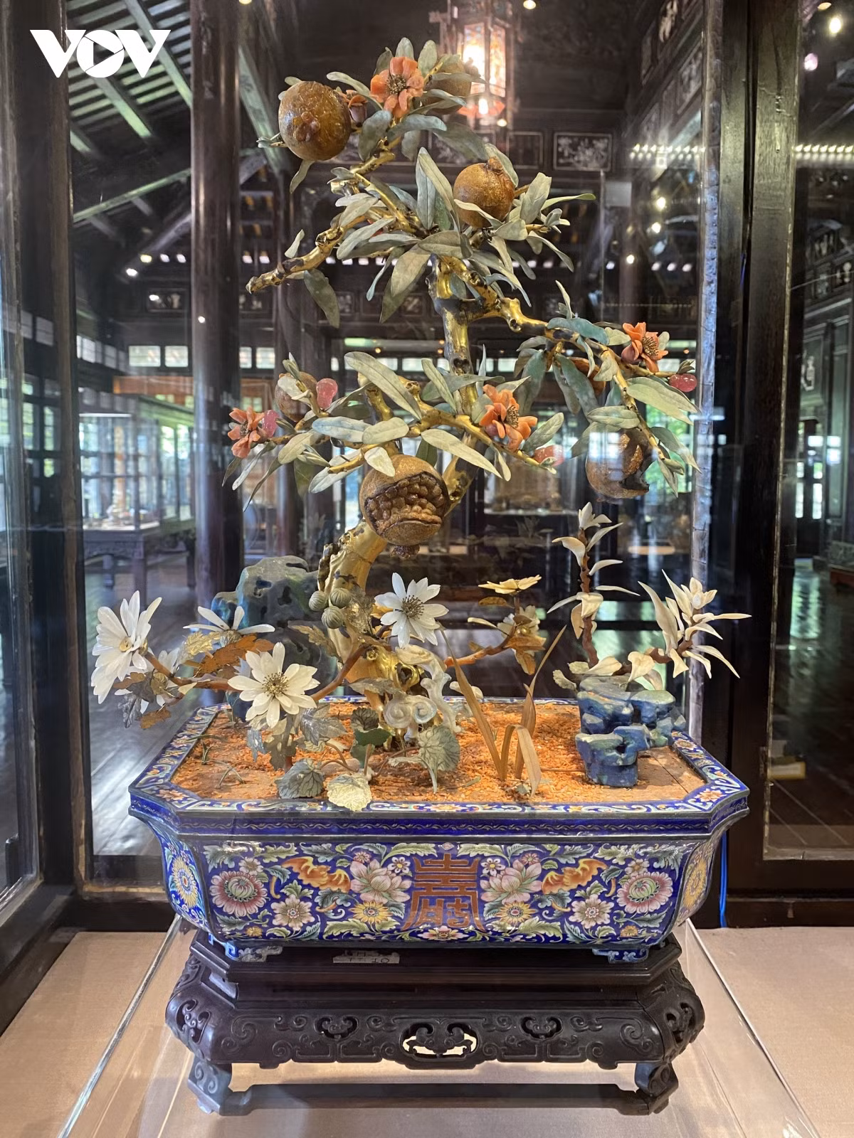 Chậu cành vàng lá ngọc (cây lựu) thân bằng gỗ thếp vàng, trái được làm bằng đá quý đỏ, lá màu xanh nhạt được đặt trong chậu bằng pháp lam. Cây lựu trang trí nội thất cung điện thời Đồng Khánh (1885 -1889).