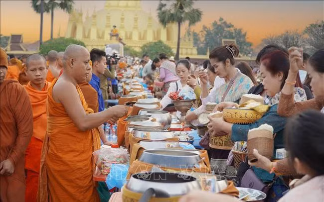 Người dân xếp hàng trang nghiêm và thực hiện nghi lễ Xaybat (cúng dường).