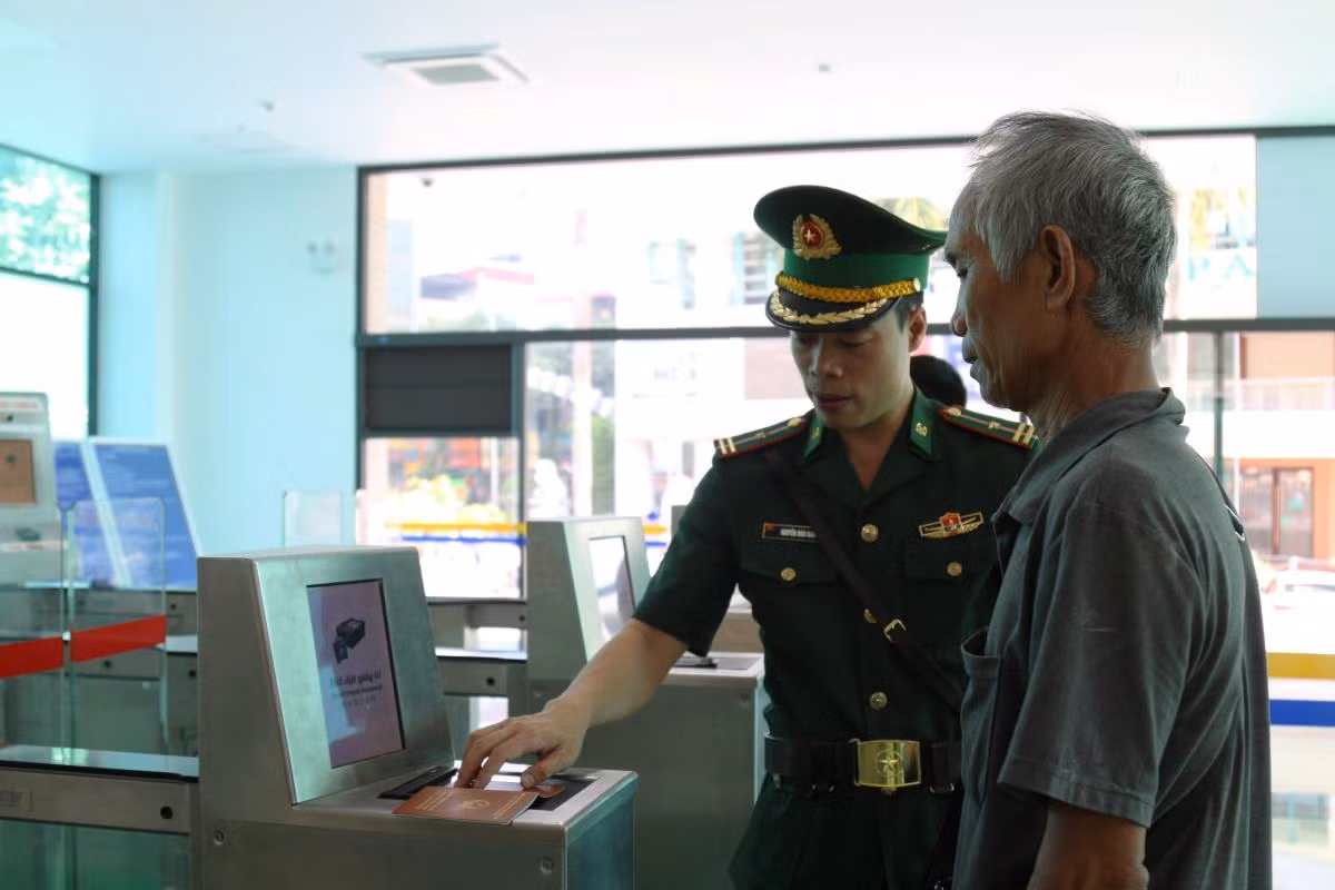 Cán bộ BĐBP Lào Cai hỗ trợ hành khách làm thủ tục xuất cảnh tại cổng kiểm soát tự động.
