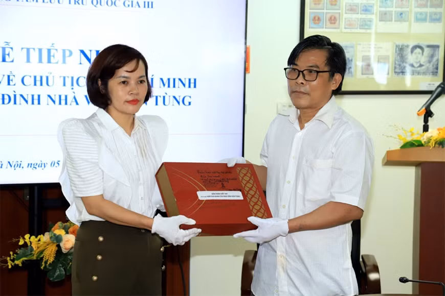 Con trai nhà văn Sơn Tùng trao tặng tài liệu cho đại diện Trung tâm Lưu trữ quốc gia III. Ảnh: Hồng L.