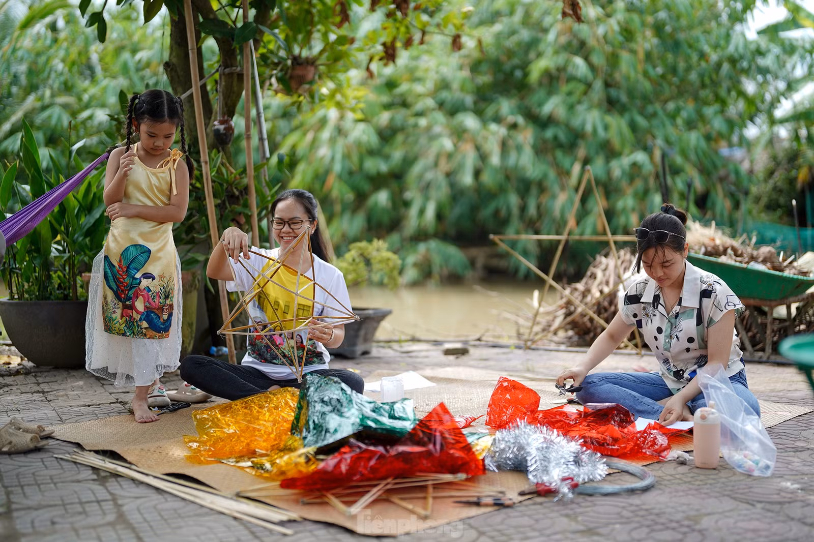 "Công đoạn nào khó thì người lớn sẽ làm phụ các con. Mấy bé thích cầm cọ quét keo và dán giấy kính. Hoạt động này cũng một phần giáo dục các bé về nét văn hóa mà ngày nay ít thấy nữa khi lồng đèn gắn pin, phát nhạc bán đại trà. Chiếc đèn ông sao truyền thống có hình sao vàng năm cánh. Đây cũng là hình ảnh quen thuộc chúng ta vẫn thường thấy trên lá quốc kỳ", chị Hồng Nhung (áo trắng) chia sẻ.
