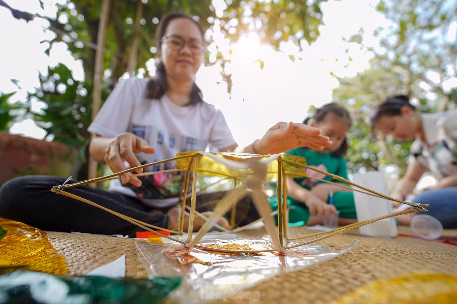 "Công đoạn nào khó thì người lớn sẽ làm phụ các con. Mấy bé thích cầm cọ quét keo và dán giấy kính. Hoạt động này cũng một phần giáo dục các bé về nét văn hóa mà ngày nay ít thấy nữa khi lồng đèn gắn pin, phát nhạc bán đại trà. Chiếc đèn ông sao truyền thống có hình sao vàng năm cánh. Đây cũng là hình ảnh quen thuộc chúng ta vẫn thường thấy trên lá quốc kỳ", chị Hồng Nhung (áo trắng) chia sẻ.