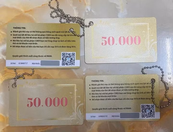Các đối tượng treo thẻ có ghi mệnh giá tiền lên xe máy hoặc cửa nhà người dân để lừa đảo. (Ảnh: Công an TP.HCM)