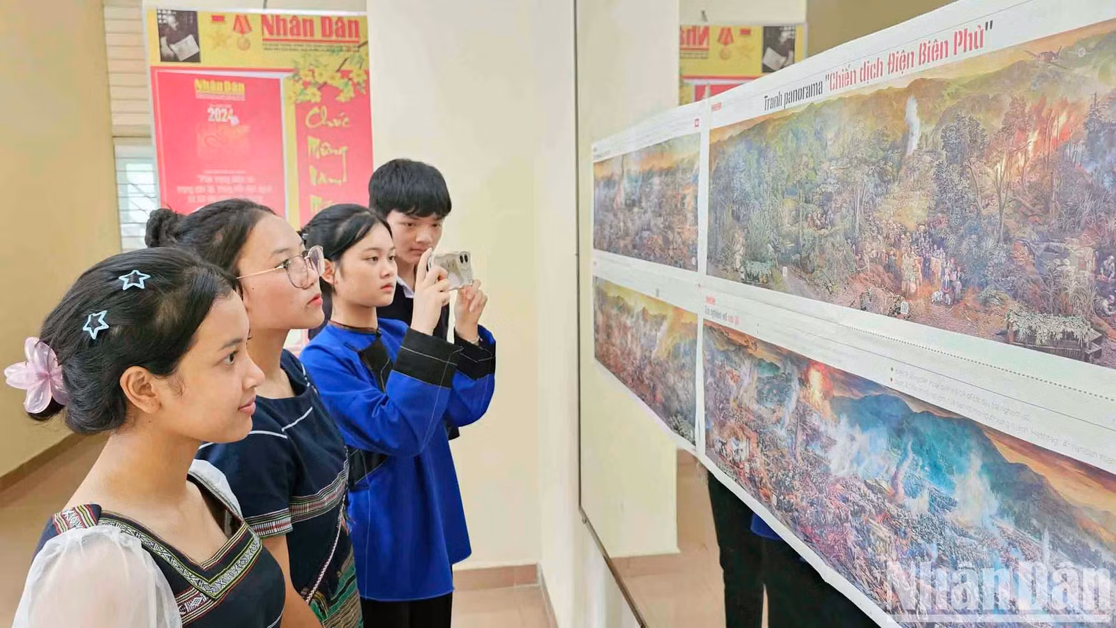 Các bạn trẻ đồng bào dân tộc thiểu số quét mã QR khám phá "bí ẩn" trên ấn bản tranh panorama "Chiến dịch Điện Biên Phủ".