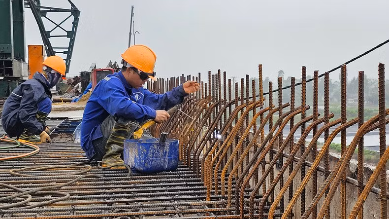 Công nhân thi công cầu Nam Khê trên tuyến đường bộ ven biển qua huyện Hậu Lộc, tỉnh Thanh Hóa.