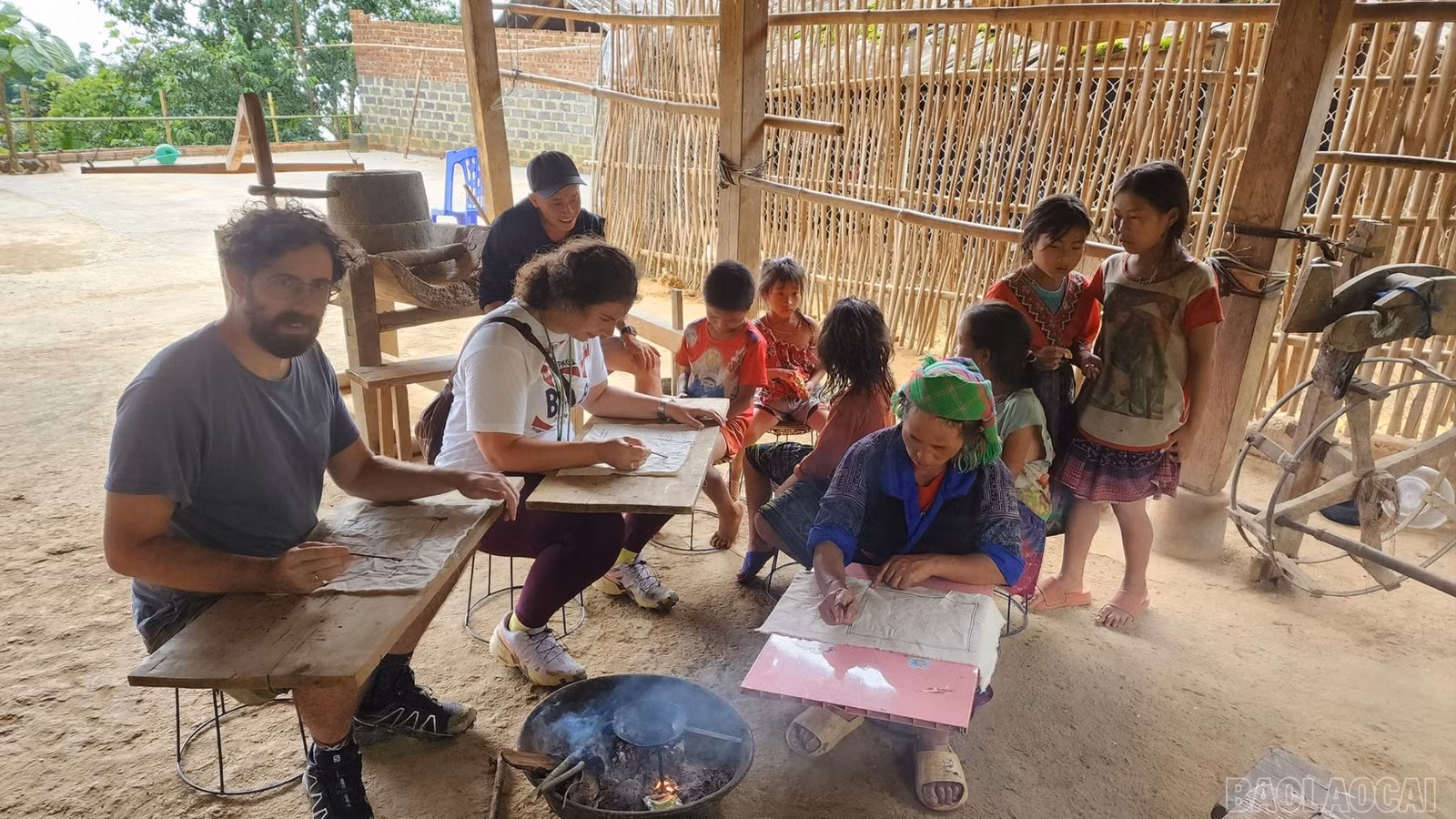 Du khách nước ngoài trải nghiệm hoạt động vẽ sáp ong của đồng bào dân tộc Mông ở Mù Cang Chải.