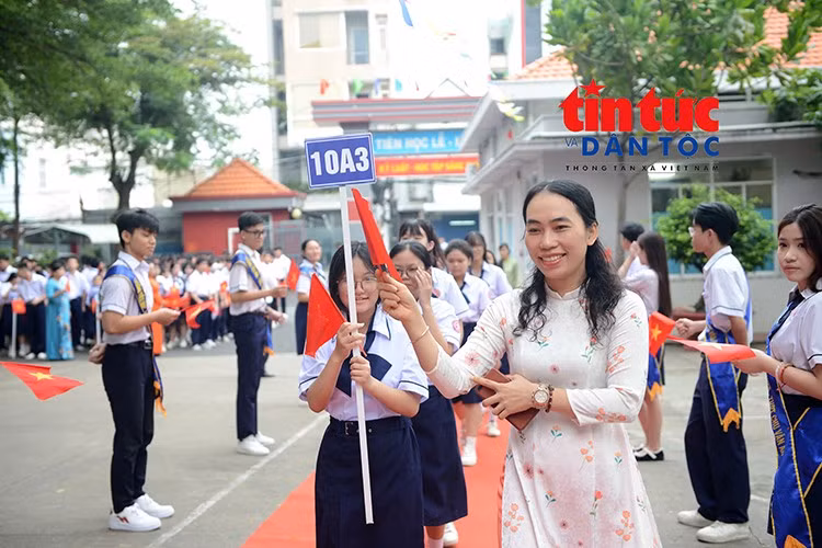 Cô giáo đồng hành cùng học sinh tiến vào lễ khai giảng, mở đầu một năm học mới với nhiều niềm vui và kỳ vọng.