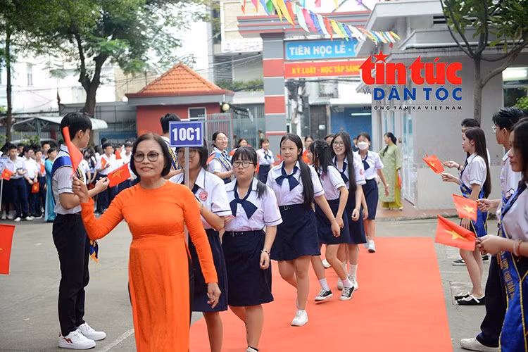 Giáo viên dẫn học sinh vào khu vực lễ khai giảng trong sự chào đón nồng nhiệt của thầy cô và các bạn.