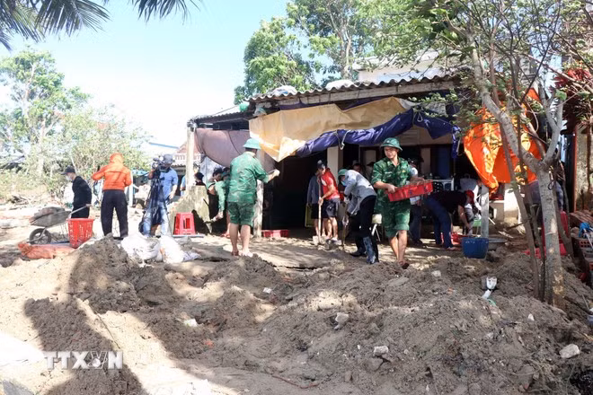 Lực lượng chức năng tham gia giúp dân xã Tịnh Khê (Quảng Ngãi) khắc phục hậu quả bão số 13.