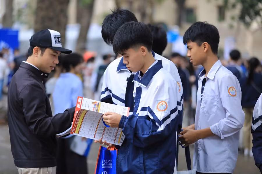 Thí sinh tìm hiểu thông tin tuyển sinh từ tờ rơi của các trường đại học.
