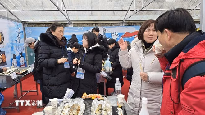 Du khách thưởng thức các món ăn từ cá hồi câu được tại lễ hội.
