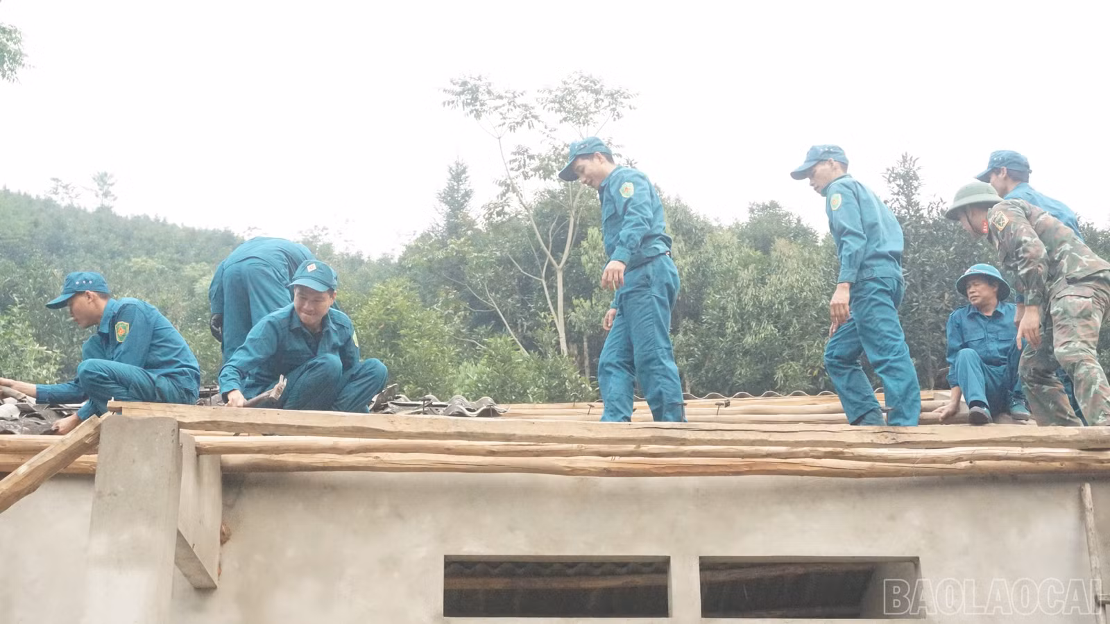 Các lực lượng giúp người dân lợp lại mái nhà.