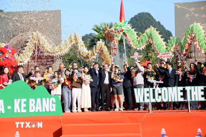 Lãnh đạo Sở Du lịch, Thể thao và Du lịch Quảng Trị, lãnh đạo Vườn Quốc gia Phong Nha - Kẻ Bàng trao hoa, quà lưu niệm chào đón 69 vị khách đầu tiên "xông đất" tham quan Di sản Thiên nhiên Thế giới năm 2026. (Ảnh: Tá Chuyên/TTXVN)