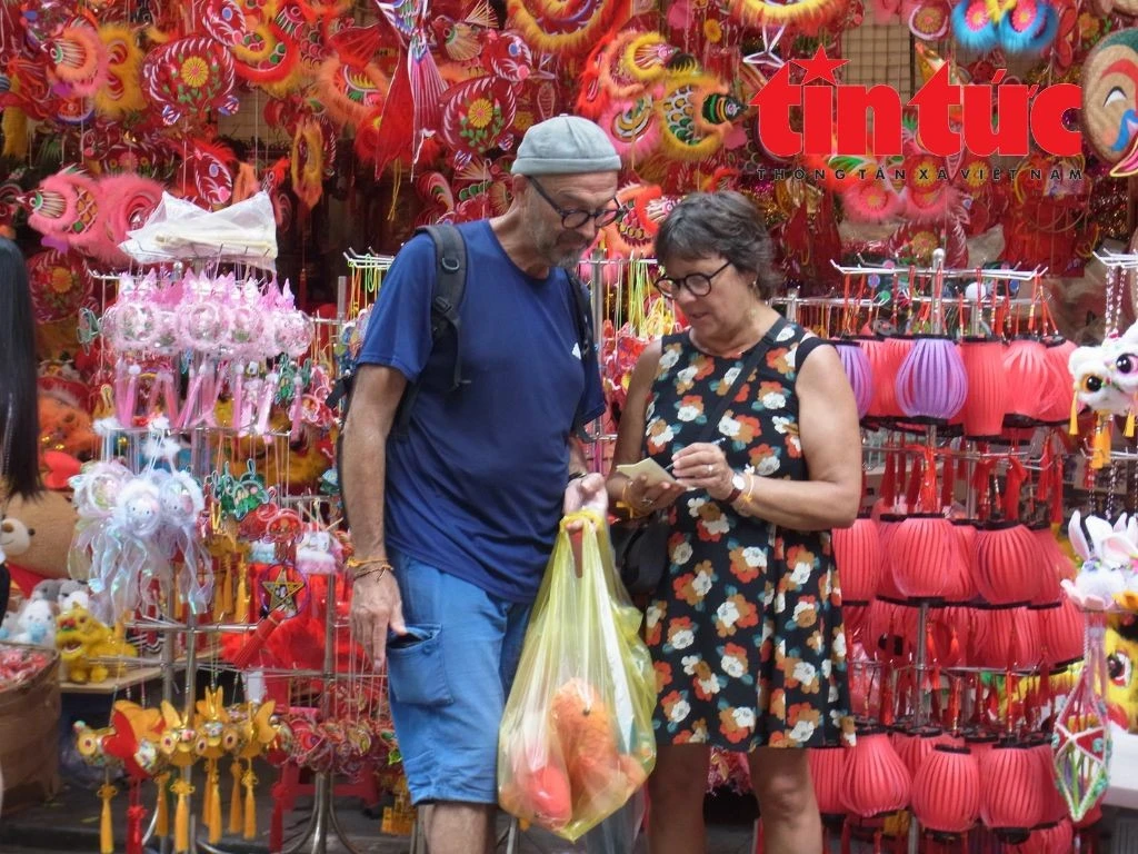 Chị Carine Hubert và chồng thích thú lựa chọn những món đồ chơi thủ công Việt Nam để mang về Pháp trang trí nhà cửa và làm quà.