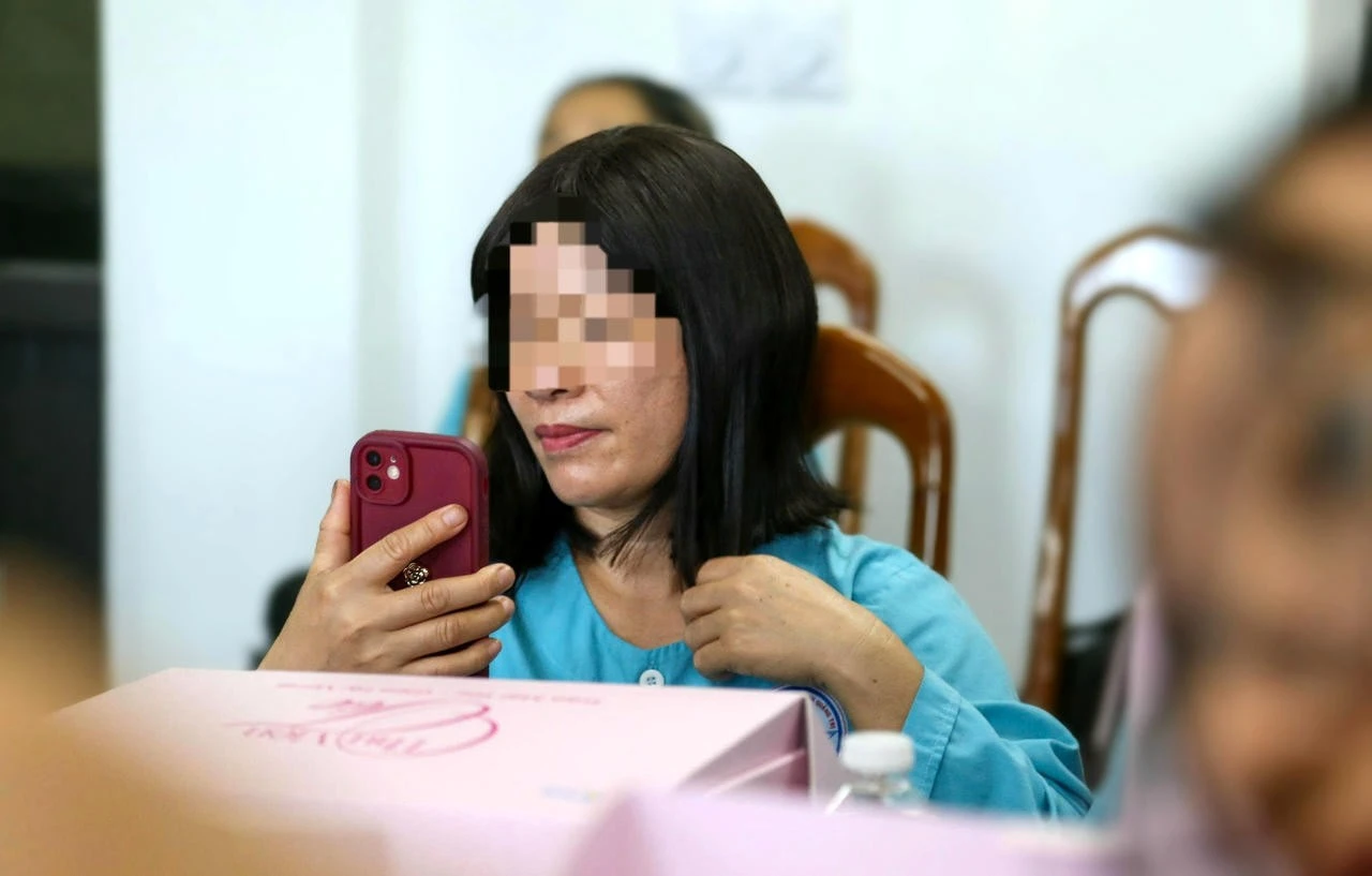 Bà N. đưa điện thoại lên soi, ngắm nghía bản thân với bộ tóc mới được trao tặng.