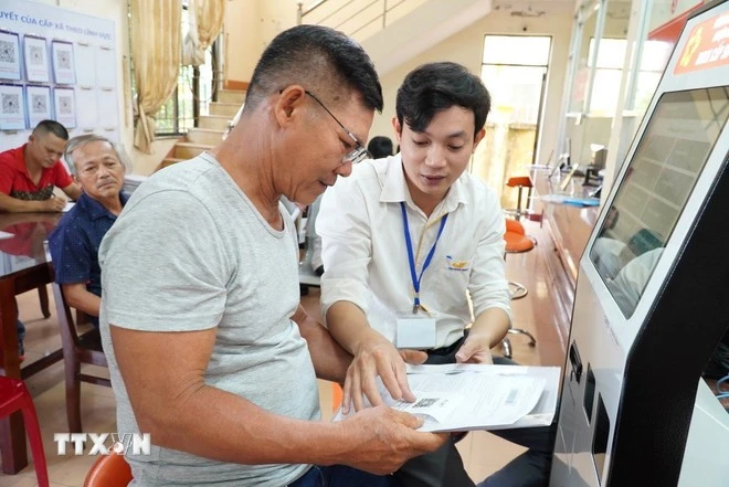 Cán bộ hướng dẫn người dân thực hiện thủ tục hành chính.