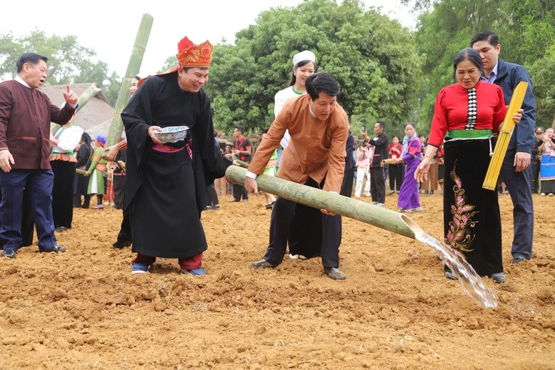 Chủ tịch nước Lương Cường cùng đồng bào thực hiện nghi thức tưới những giọt nước đầu tiên xuống đồng cho mưa thuận gió hòa, quốc thái dân an, thái bình thịnh vượng - Ảnh: VGP/ Văn Hiền