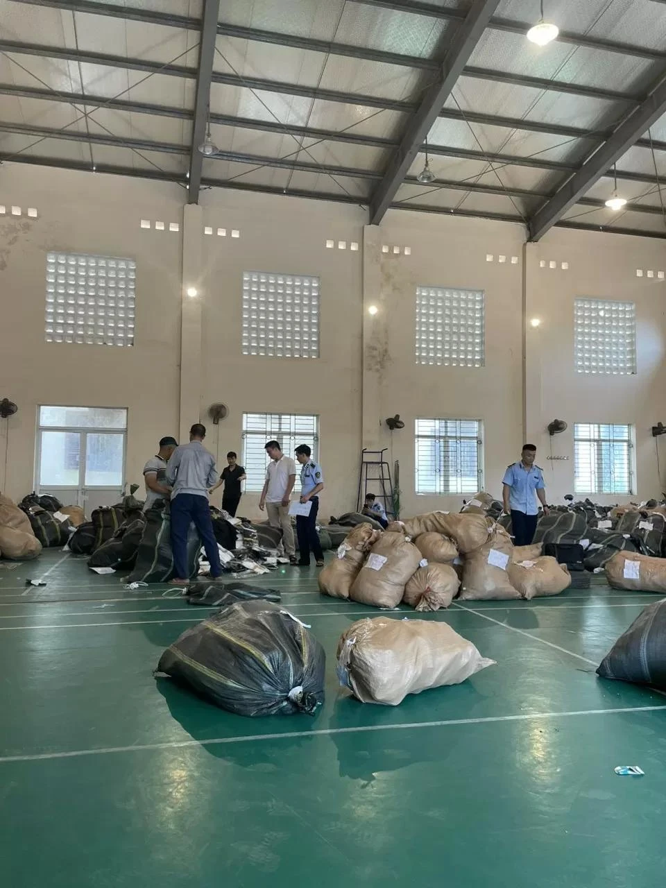 Lực lượng chức năng khám kho và kiểm đếm hàng hóa vi phạm. (Ảnh: Tổng cục Quản lý thị trường)