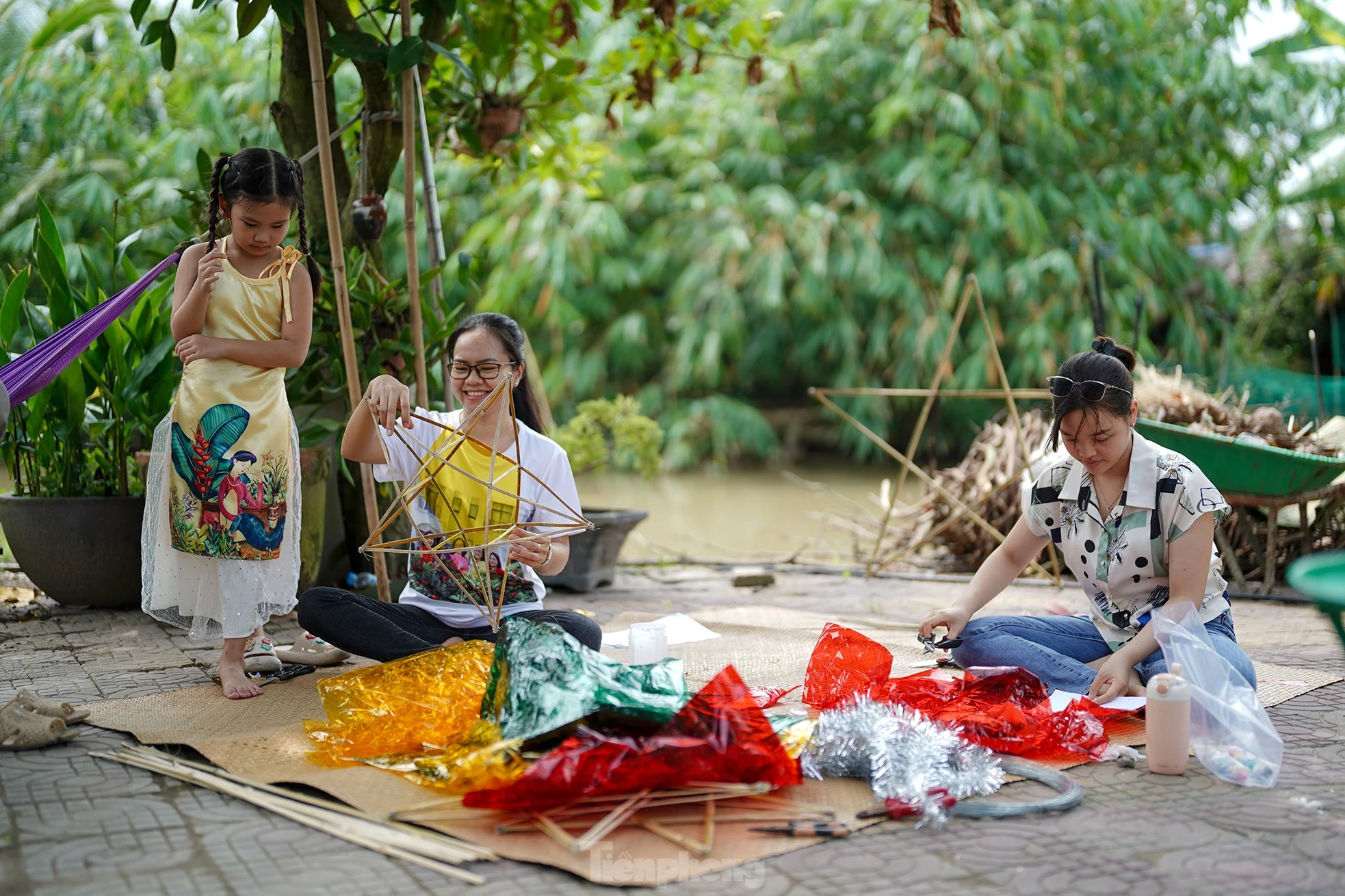 "Công đoạn nào khó thì người lớn sẽ làm phụ các con. Mấy bé thích cầm cọ quét keo và dán giấy kính. Hoạt động này cũng một phần giáo dục các bé về nét văn hóa mà ngày nay ít thấy nữa khi lồng đèn gắn pin, phát nhạc bán đại trà. Chiếc đèn ông sao truyền thống có hình sao vàng năm cánh. Đây cũng là hình ảnh quen thuộc chúng ta vẫn thường thấy trên lá quốc kỳ", chị Hồng Nhung (áo trắng) chia sẻ.