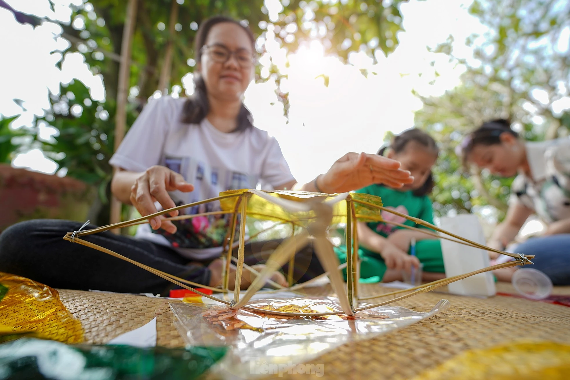 "Công đoạn nào khó thì người lớn sẽ làm phụ các con. Mấy bé thích cầm cọ quét keo và dán giấy kính. Hoạt động này cũng một phần giáo dục các bé về nét văn hóa mà ngày nay ít thấy nữa khi lồng đèn gắn pin, phát nhạc bán đại trà. Chiếc đèn ông sao truyền thống có hình sao vàng năm cánh. Đây cũng là hình ảnh quen thuộc chúng ta vẫn thường thấy trên lá quốc kỳ", chị Hồng Nhung (áo trắng) chia sẻ.