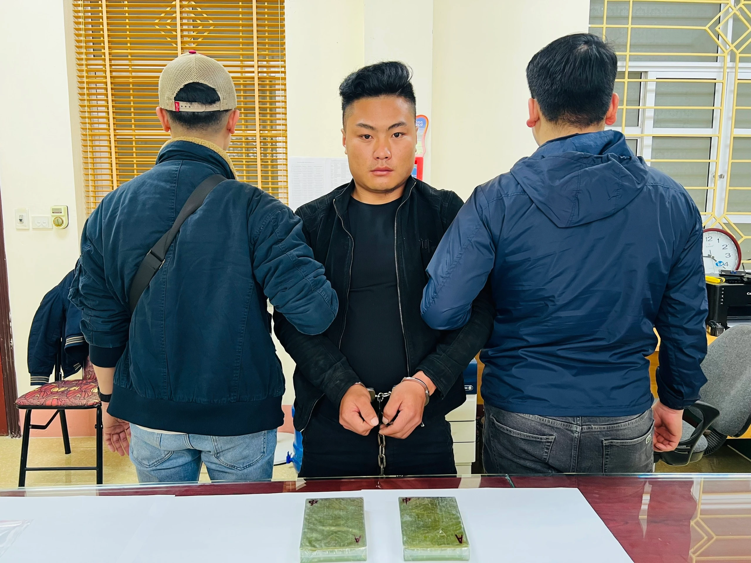 Ảnh 1. Đối tượng Giàng Seo Sín cùng tang vật tại cơ quan Công an.jpg