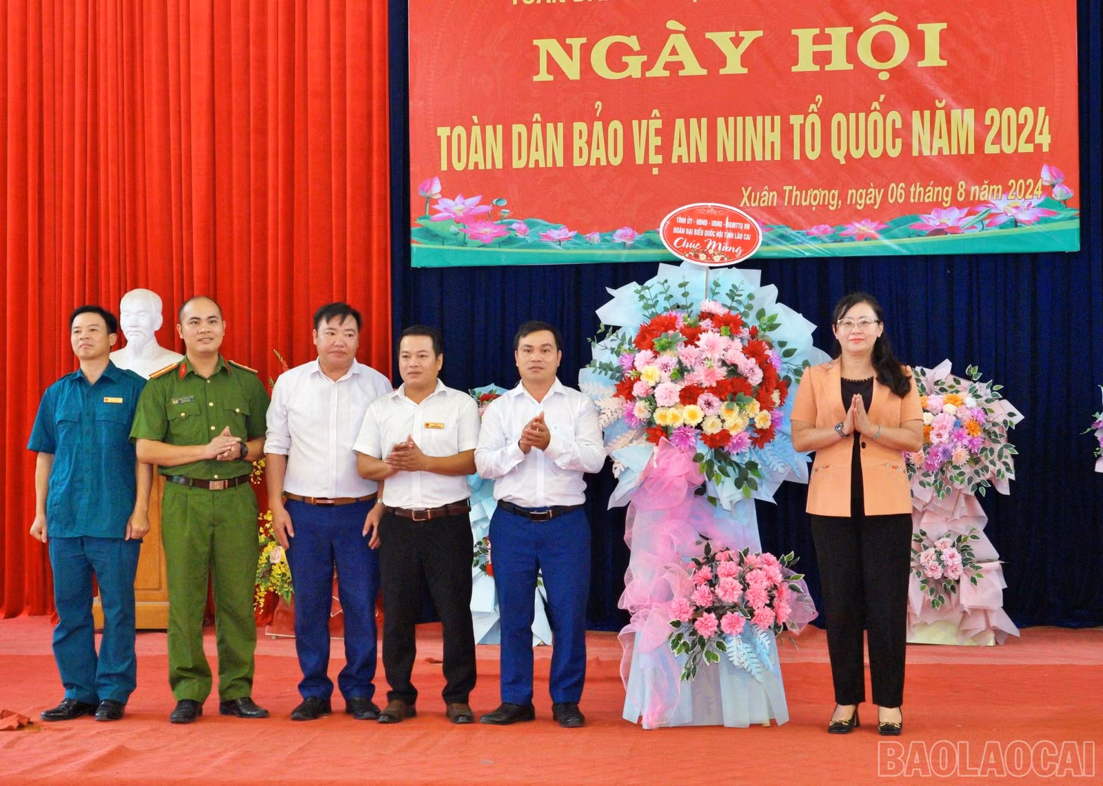 Đồng chí Giàng Thị Dung thay mặt Tỉnh ủy, HĐND, UBND tỉnh tặng hoa chúc mừng Đảng ủy, HĐND, UBND xã Xuân thượng, huyện Bảo Yên.