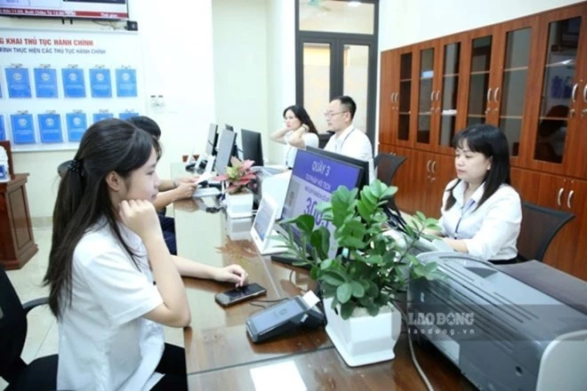 Bộ Nội vụ nêu các tiêu chí để địa phương chủ động bố trí, giao, điều chỉnh biên chế cấp xã. Trong ảnh, người dân phường Cầu Giấy (Hà Nội) giải quyết thủ tục hành chính. Ảnh: Phạm Đông