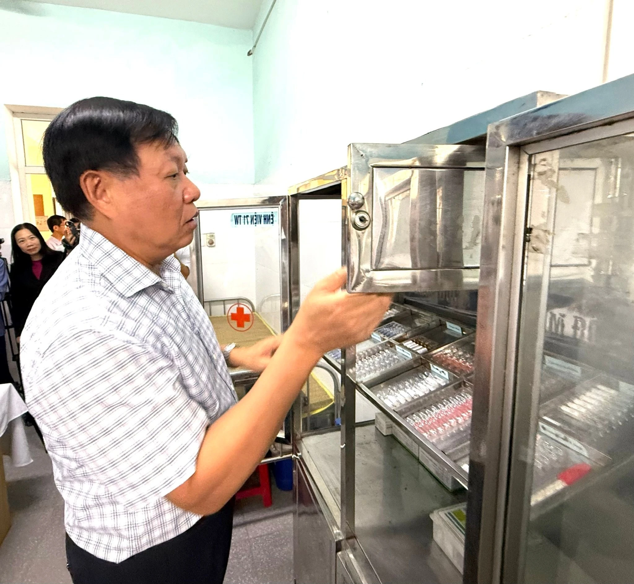 Thứ trưởng Bộ Y tế Đỗ Xuân Tuyên kiểm tra tủ thuốc tại một trạm y tế xã của tỉnh Ninh Bình. Ảnh: Thái Bình