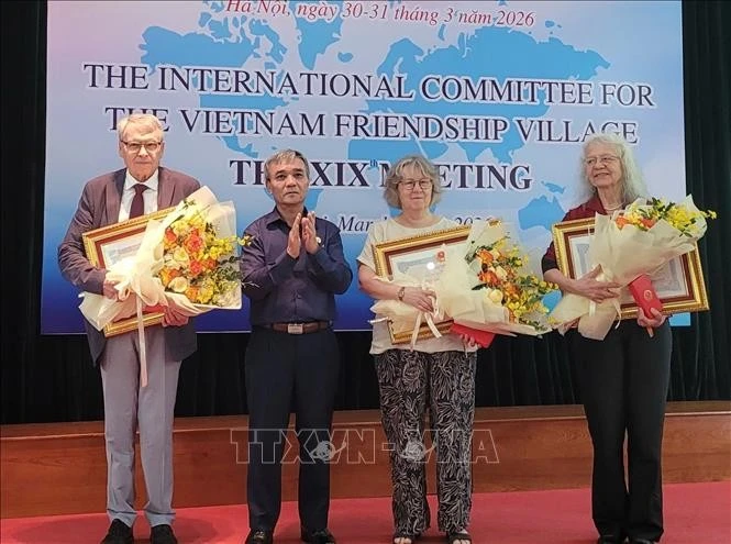 Thừa ủy quyền của Chủ tịch nước, Thượng tướng Phạm Hồng Hương, Phó Chủ tịch Hội Cựu chiến binh Việt Nam trao Huân, Huy chương cho các thành viên Ủy ban Quốc tế có nhiều đóng góp cho Làng Hữu nghị.