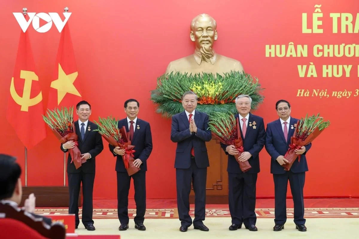 Tổng Bí thư Tô Lâm tặng hoa chúc mừng các đồng chí được nhận Huy hiệu Đảng.