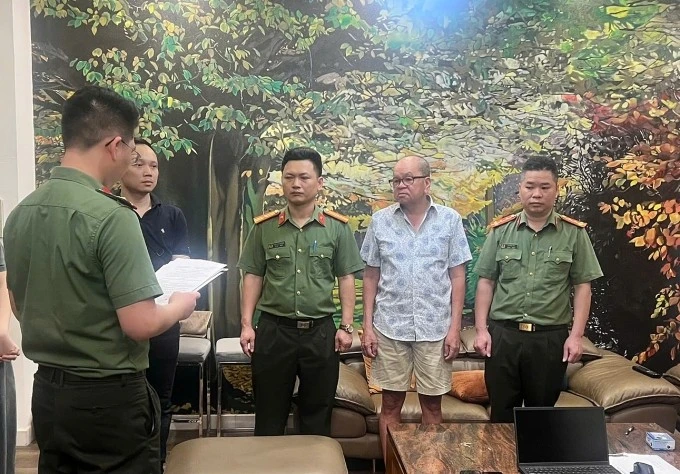 Công an tống đạt quyết định khởi tố Trần Văn Quận. Ảnh: Công an cung cấp