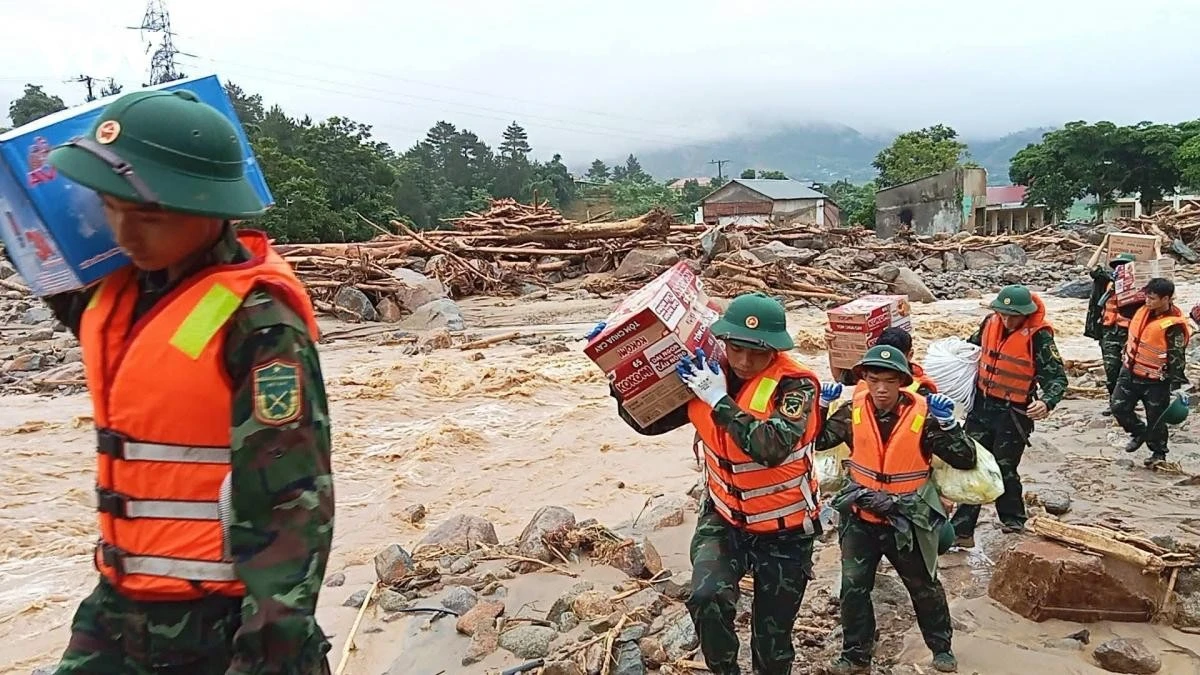 Cán bộ, chiến sĩ Bộ CHQS tỉnh Lai Châu vận chuyển nhu yếu phẩm cho bà con bản Chít bị cô lập vì nước lũ.