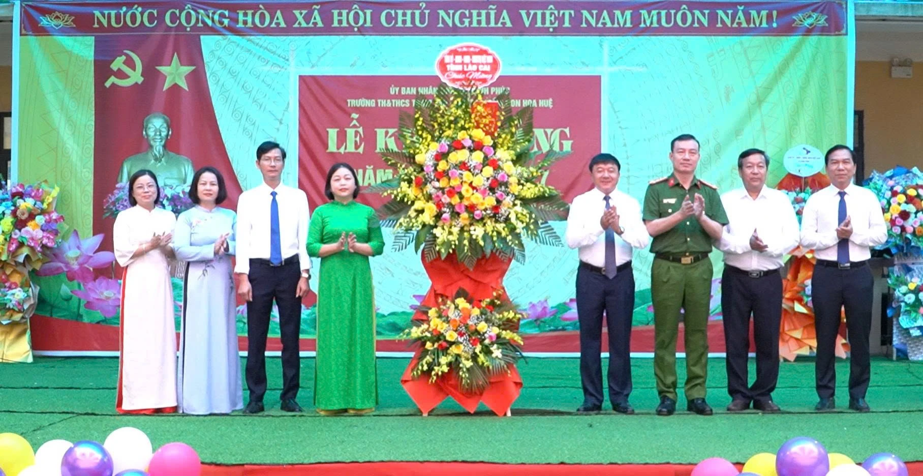 Các đại biểu tặng hoa chúc mừng Trường Tiểu học và Trung học cơ sở xã Hạnh Phúc, Trường Mầm non Hoa Huệ.