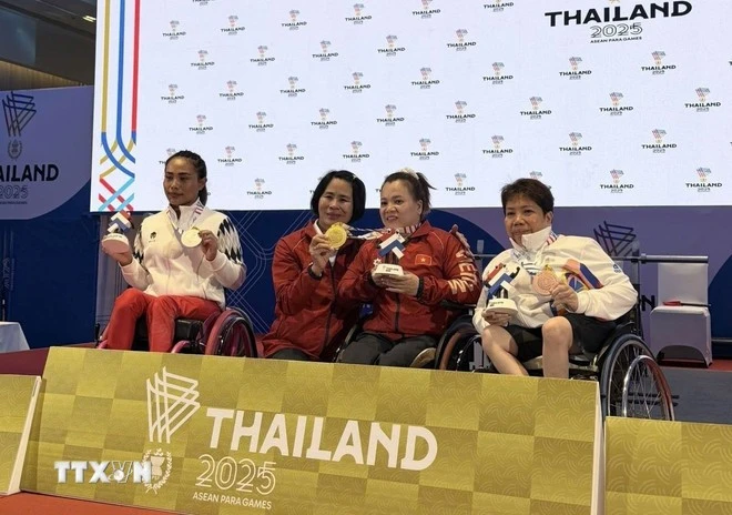Đô cử Đặng Thị Linh Phượng chia sẻ niềm vui chiến thắng với Trưởng đoàn thể thao người khuyết tật Việt Nam tại ASEAN Para Games 13 Lê Thị Hoàng Yến và người hâm mộ. (Ảnh: Đỗ Sinh/TTXVN)