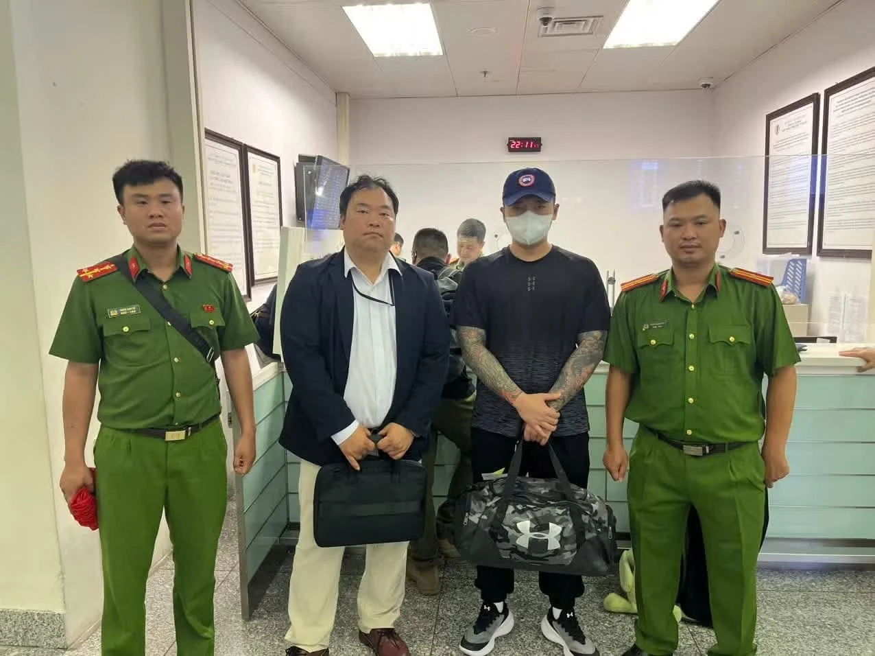 Lực lượng Công an bàn giao đối tượng Lee Sammin cho phía Hàn Quốc (áo đen, đứng thứ 3 từ trái sang).