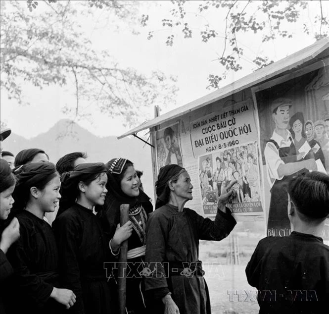 Đồng bào dân tộc Mán xem tranh cổ động bầu cử Quốc hội khóa II (1960).