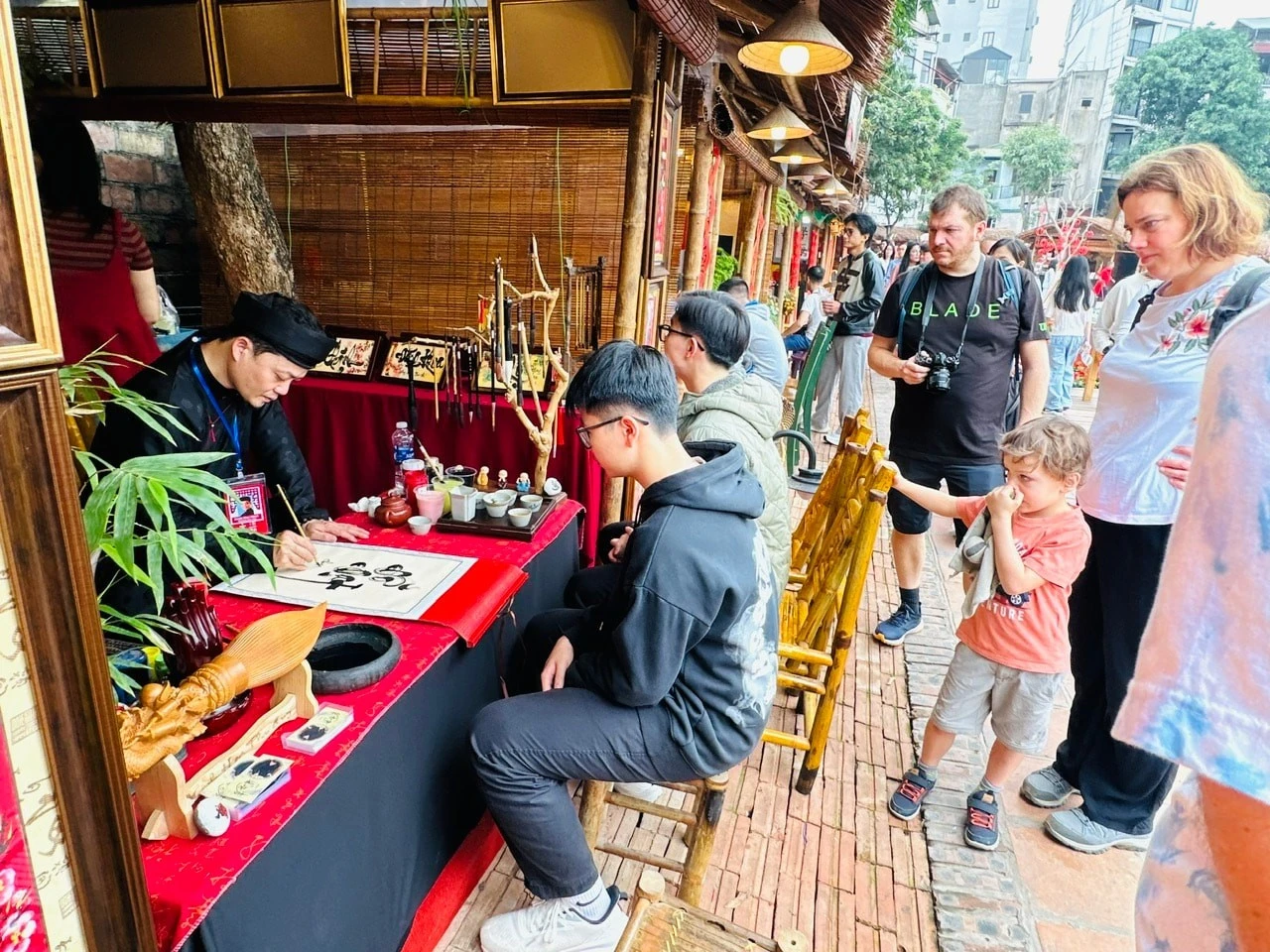 Hoạt động xin chữ đầu năm thu hút rất đông bạn trẻ và khách nước ngoài tại Văn Miếu - Quốc Tử Giám.