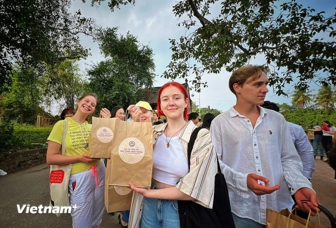 Du khách quốc tế nhận quà sau khi trải nghiệm làng cổ Đường Lâm.